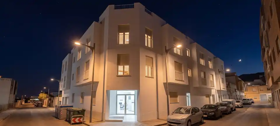 Tu casa en C/ Polseguera 8, al anochecer, con el portal y las ventanas iluminados: recreación orientativa