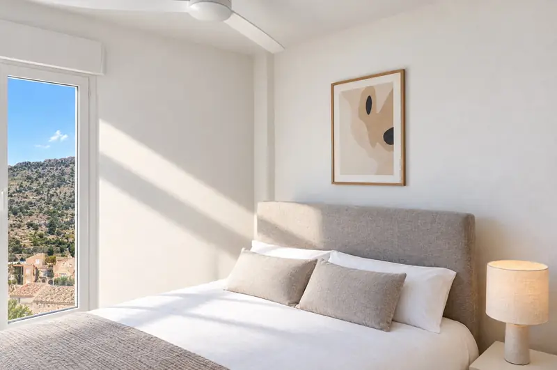 Dormitorio luminoso con una ventana a la sierra