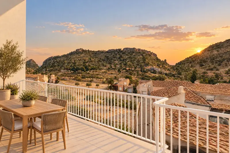 Terraza de ático al atardecer, con mesa y vistas